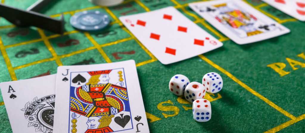 Gambling board game.Cards, chips, roulette.Gaming flat lay. Close-up of a card for playing poker on a gaming table in a casino against a background of chips. Background for the gaming business.